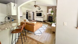 Una cocina moderna con encimera de granito, horno empotrado y ventilador de techo.