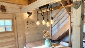 Un intérieur en bois comprenant une table à manger, des chaises et un vase avec des fleurs séchées.