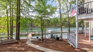 Terraza junto al lago con muelle, mesa de picnic y zona de estar al aire libre.