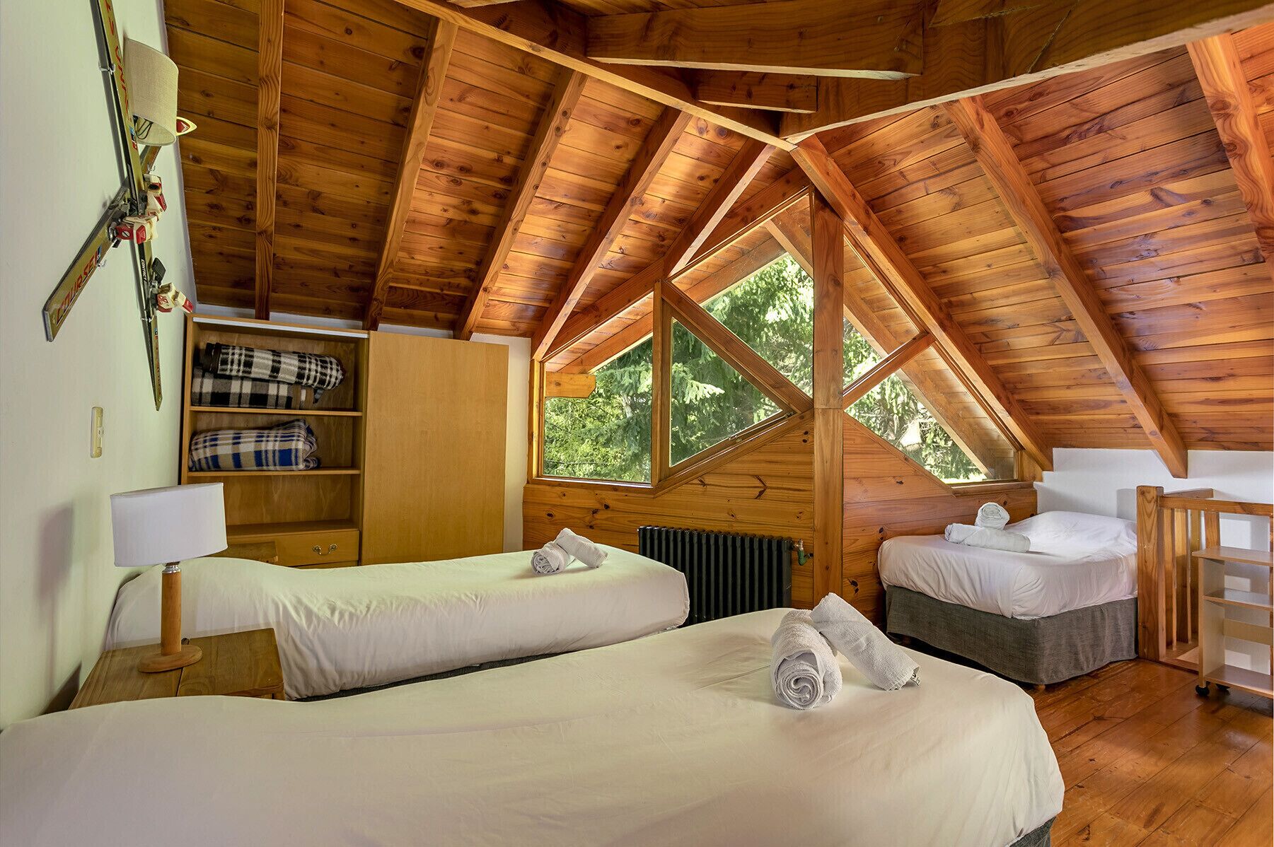 Un chalet confortable avec deux lits, un plafond en bois et une grande fenêtre.