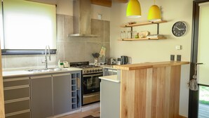 Una cocina moderna con gabinetes grises, una isla de madera, una estufa y un reloj en la pared.