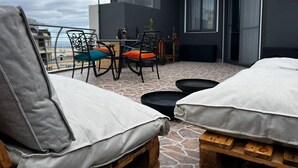 A rooftop terrace with two lounge chairs, a table, and chairs. - Trendy Seaside Escape |Designer Finished Penthouse

 (Wied il-Ghajn)