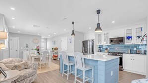A modern kitchen with white cabinets, a blue island, and stainless steel appliances. - 3BR Wildwood Crest Family Home - Easy walk 2 beach (Wildwood Crest)