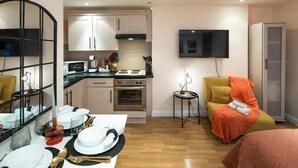 A compact living space with a kitchenette, a dining area, a TV mounted on the wall, and a bed. - 5minwalk2 Bakerstreet/centrallnd (London)