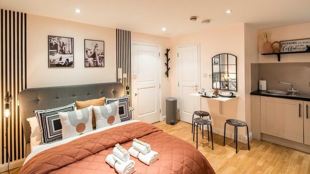 A modern bedroom with a large bed, a small kitchenette, and a bathroom. - 5minwalk2 Bakerstreet/centrallnd (London)