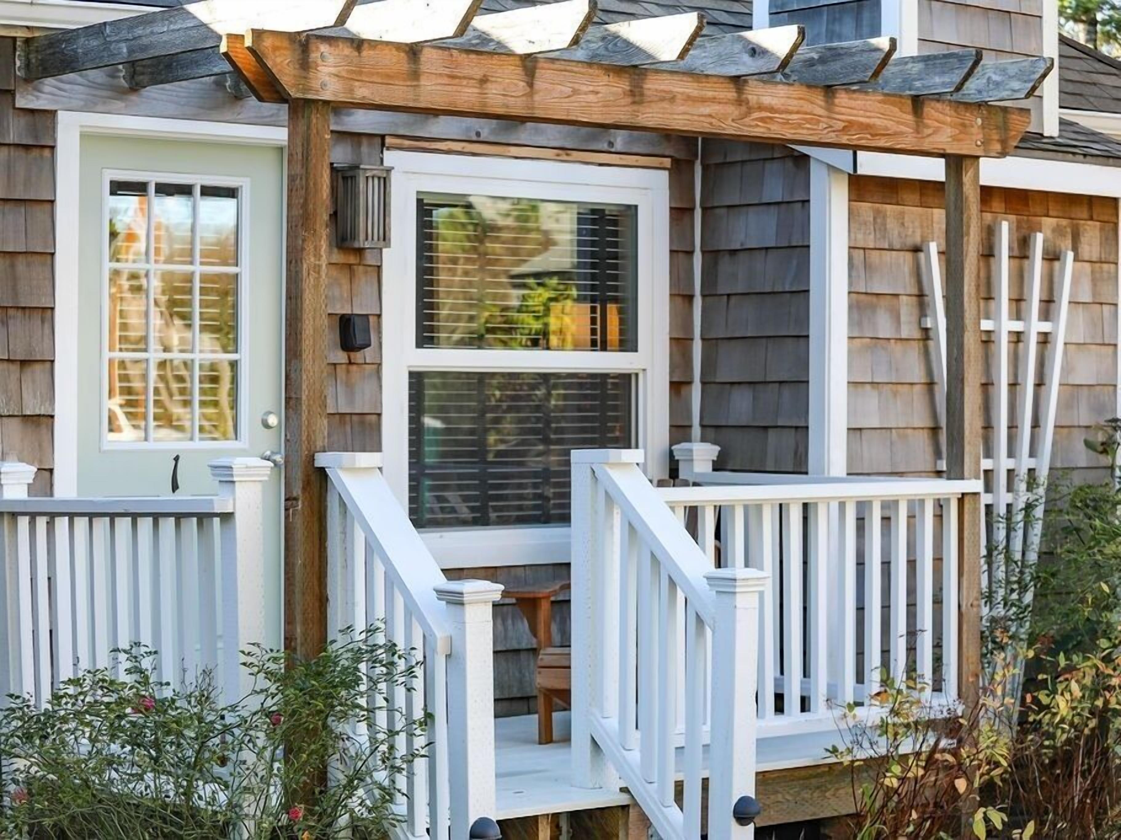 A house with a covered porch, a front door, and a window.