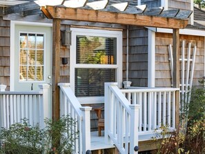 A house with a covered porch, a front door, and a window.