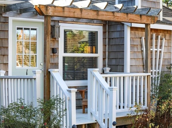 A house with a covered porch, a front door, and a window.