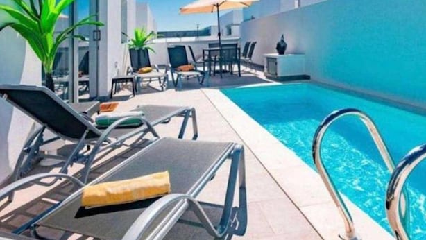 A rooftop pool area with lounge chairs, a table, and umbrellas. - Villa Janubio With 3 Bedrooms and 2 Bathrooms (Yaiza)