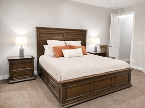 A bedroom with a large bed, two bedside tables, and a door. - Two Heated Pools/Spas, BBQ, Golf Course (Washington)