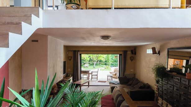 A spacious loft with a wooden staircase, a balcony with a view, and a cozy seating area with a sofa and a coffee table. - Location Grande Villa au Soleil D'avignon (Châteauneuf-de-Gadagne)