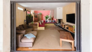 A living room with a sofa, a coffee table, and a TV. - Location Grande Villa au Soleil D'avignon (Châteauneuf-de-Gadagne)