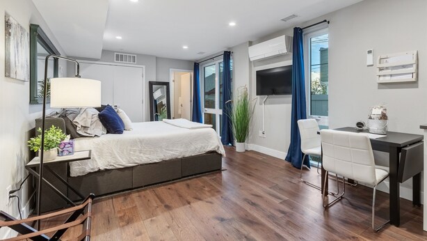 Une chambre moderne comprenant un lit, une table de chevet, une lampe et un bureau avec une chaise.
