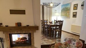 A living room with a fireplace, floral sofas, a dining area with chairs, and a tiled floor. - La Ponie - Cenves - Gîte (CENVES)