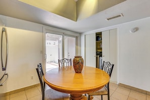 A dining area with a round wooden table, a colorful vase, and two chairs. - Pet-friendly Phoenix Townhome w/ Pool Access! (Phoenix)