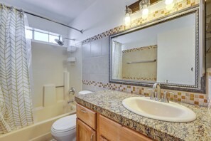 A bathroom with a bathtub, toilet, sink, and a large mirror. - Pet-friendly Phoenix Townhome w/ Pool Access! (Phoenix)