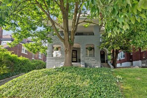 A two-story house with a large tree in front, surrounded by a well-maintained lawn and hedges. - Cincinnati Apartment: 1 Mi to Hyde Park Square! (Cincinnati)