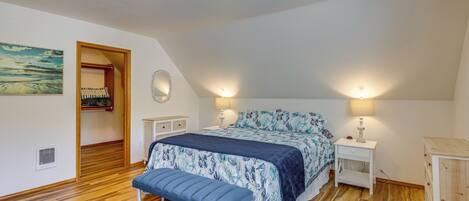 A bedroom with a bed, bedside tables, a bench, a wardrobe, and a painting on the wall.