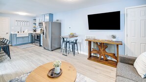 A modern living room with a wooden coffee table, a gray sofa, and a TV mounted on the wall. - Waterfront Lake Hamilton Vacation Rental w/ Dock! (Royal)