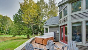 Eine Terrasse mit Sitzgelegenheit im Freien, einem Whirlpool und einer Feuerstelle.