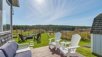 Relax on the deck with a sofa and Adirondack chairs, taking in the serene forest views.