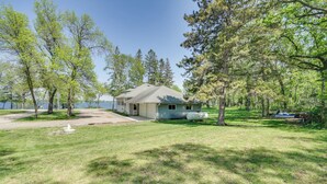 A house with a large lawn, a boat, and trees. - Lakeside Litchfield Home w/ Patio & Gas Grill! (Litchfield)
