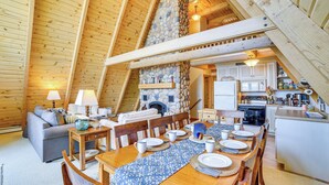 A cozy, wooden interior with a dining area, kitchen, and living space. - Upper Peninsula Lakefront A-frame Cabin w/ Dock (Channing)