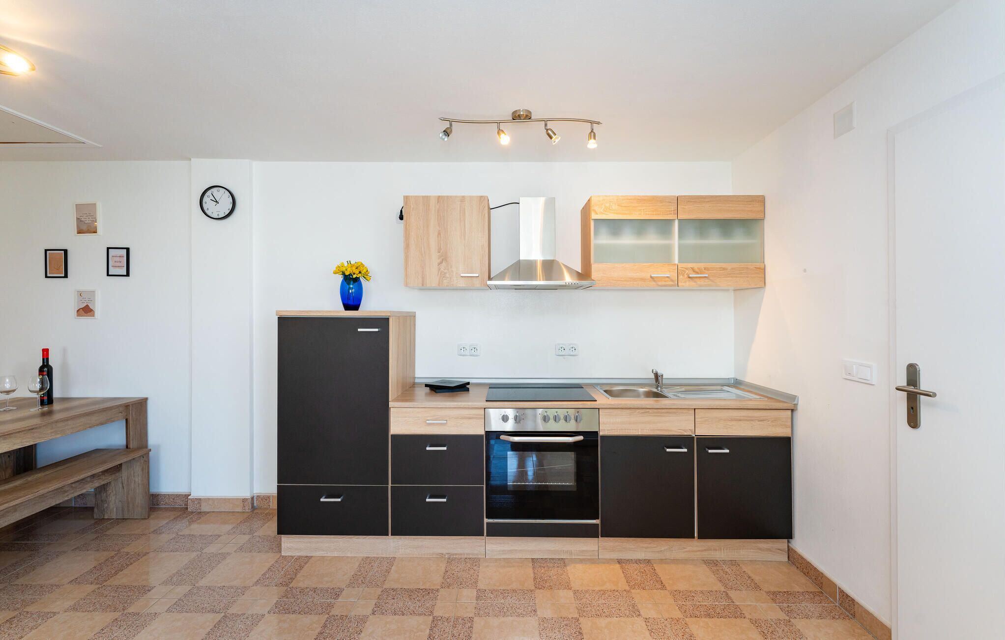 A modern kitchen with a built-in oven, a sink, and wooden cabinets.