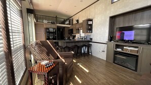 A modern kitchen with a central island, bar stools, and a built-in TV. - WALK TO INDIAN RIVER MARINA AT NORRIS LAKE
Book now! Memorial Weekend available (Jacksboro)