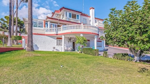 A two-story house with a balcony, a covered porch, and a well-maintained lawn. - Gorgeous apartment in Malaga with house sea view (Malaga)