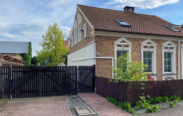 A two-story house with a brick facade, white window frames, and a tiled roof. - 2 bedroom amazing apartment in Nowe Warpno (Nowe Warpno)