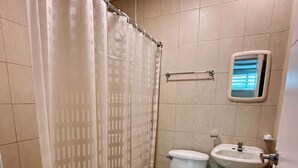 A bathroom with a shower curtain, a toilet, a bidet, and a sink. - Mini Suite Equipada Frente al Aeropuerto! (Guayaquil)