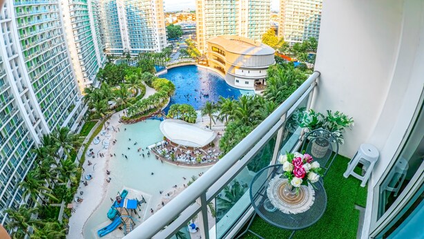 A high-rise hotel with a rooftop pool, a water slide, and a lounge area with outdoor seating. - Stunning 1-bed Apartment in Paranaque (Parañaque)