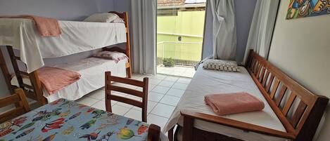 Un dormitorio con literas, una cama individual y una mesa con mantel colorido.