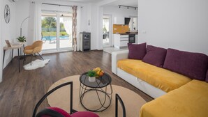Un salon moderne avec un canapé, une table à manger et une cuisine en arrière-plan.