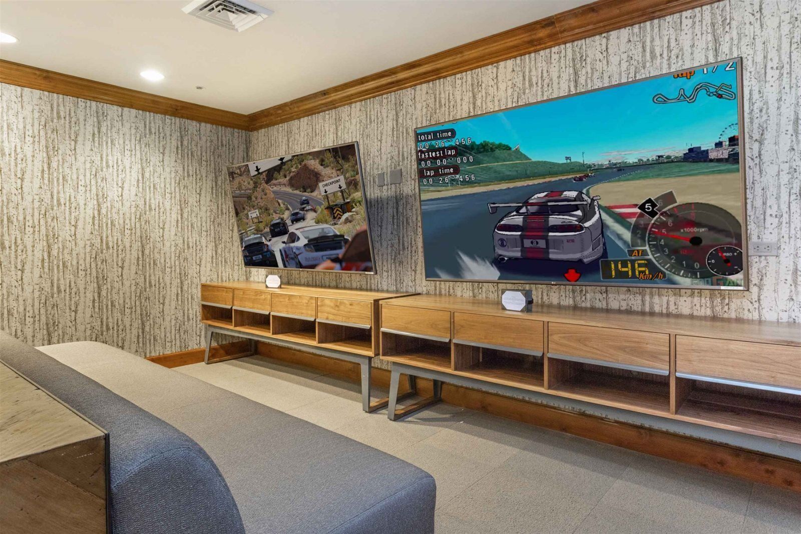 Ein Zimmer mit einer hölzernen Bank, zwei großen Postern an der Wand und einem Deckenlüfter.