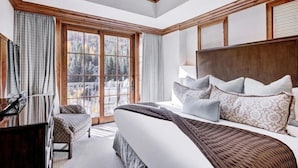 A hotel room with a large bed, a piano, and a view of the outdoors through a large window. - Vail Ritz Carlton 3 Bedroom Residence (Vail)