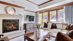A living room with a fireplace, a sofa, and a coffee table. - Vail Ritz Carlton 3 Bedroom Residence (Vail)