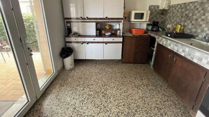 A compact kitchen with white cabinets, a microwave, and a small sink. - Maison de 2 Chambres Pour 4 Personnes (Marseillan)