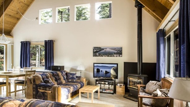 Ein gemütliches Wohnzimmer mit einer Couch, einem Fernseher, einem Kamin und einem Essbereich.