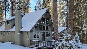 A cabin with a steeply pitched roof, large windows, and a deck. - Agate Bay Pines (Carnelian Bay)