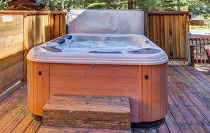 A hot tub on a wooden deck with a wooden fence in the background. - Evans Cabin (Carnelian Bay)