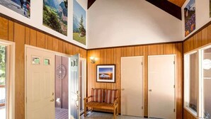 A hotel lobby with wooden paneling, a bench, and doors leading to rooms. - O`Rourke Cabin, 4BD/2BA (Carnelian Bay)