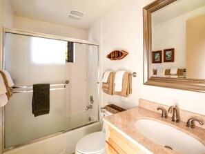 A bathroom with a glass-enclosed shower, a white toilet, a sink with a marble countertop, and a mirror with a wooden frame. - O`Rourke Cabin, 4BD/2BA (Carnelian Bay)