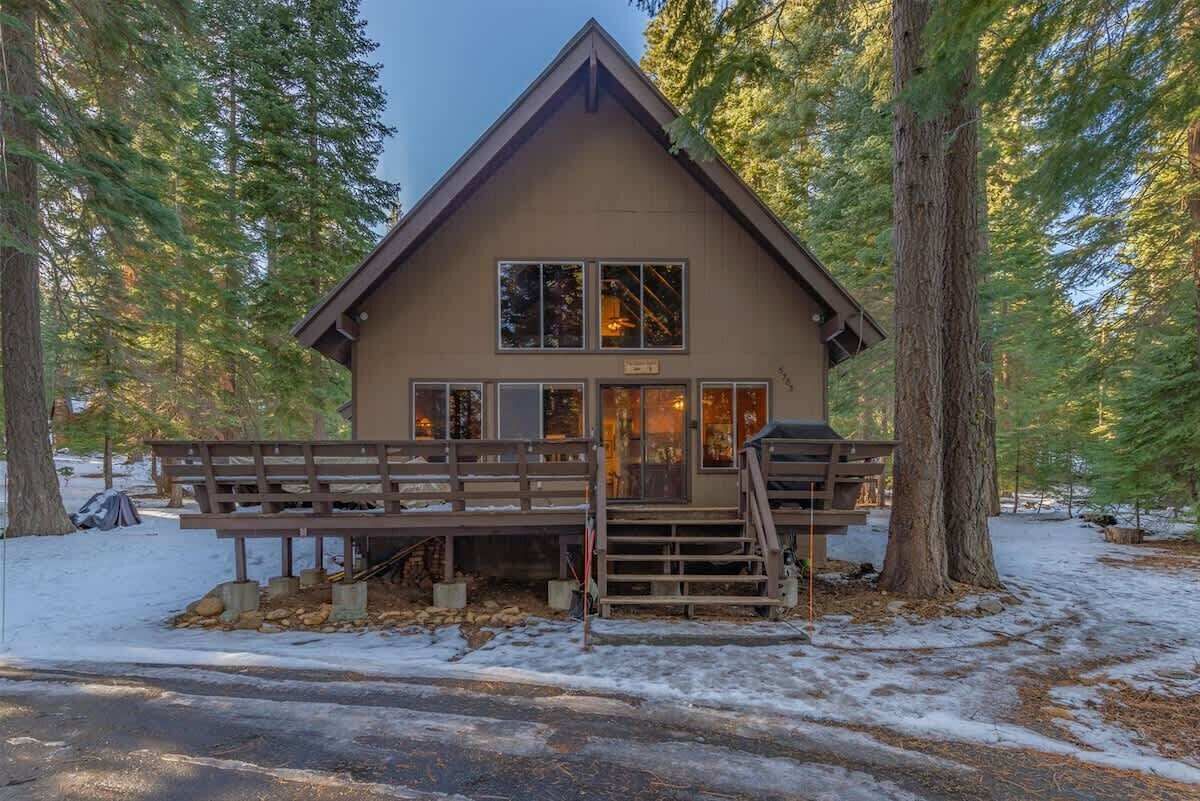 A lodge with a wooden exterior, a front porch, and a staircase leading to the entrance.
