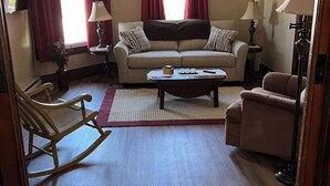 A living room with a sofa, rocking chair, and coffee table. - Millheim Mallard Place (Millheim)