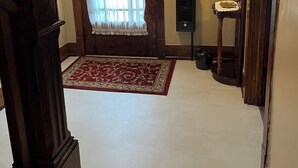 A wooden door with a white curtain, a small rug, and a coat rack. - Millheim Mallard Place (Millheim)