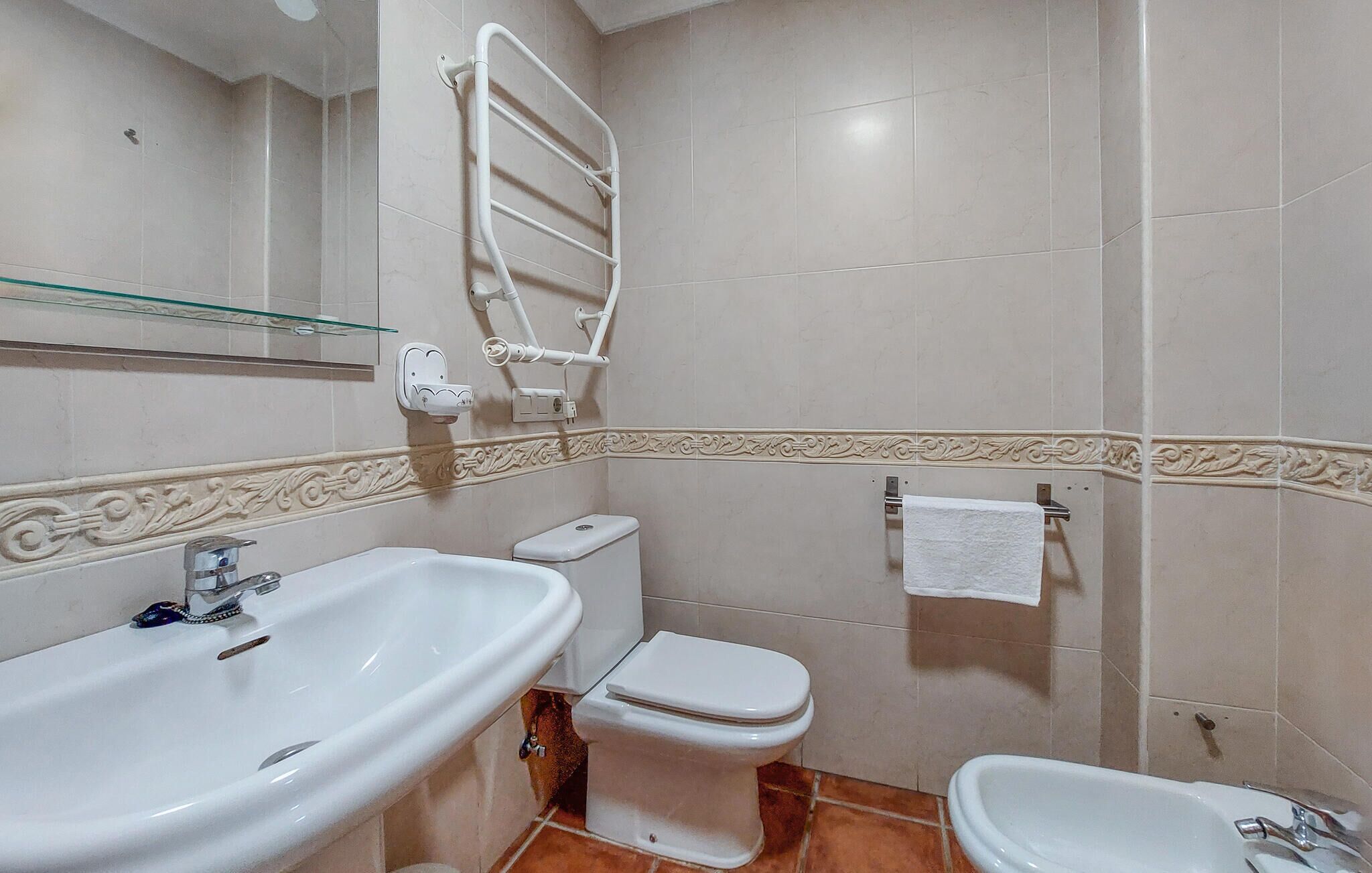 Un bany amb rentatge, vàter, bidet i paraula per a tovalloles.