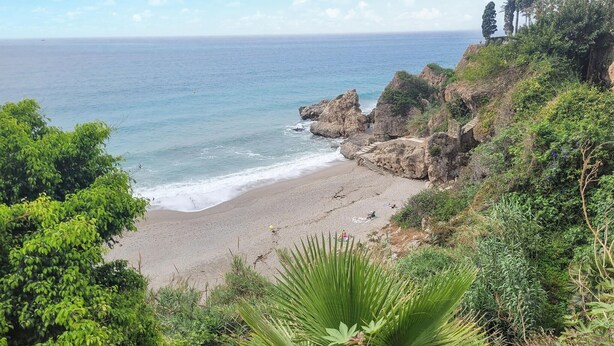 A beach with rocky cliffs, greenery, and a clear view of the ocean. - 2 bedroom stunning apartment in Nerja (Nerja)