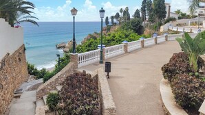 A coastal walkway with a stone wall, steps leading down to the beach, and a railing overlooking the ocean. - 2 bedroom stunning apartment in Nerja (Nerja)
